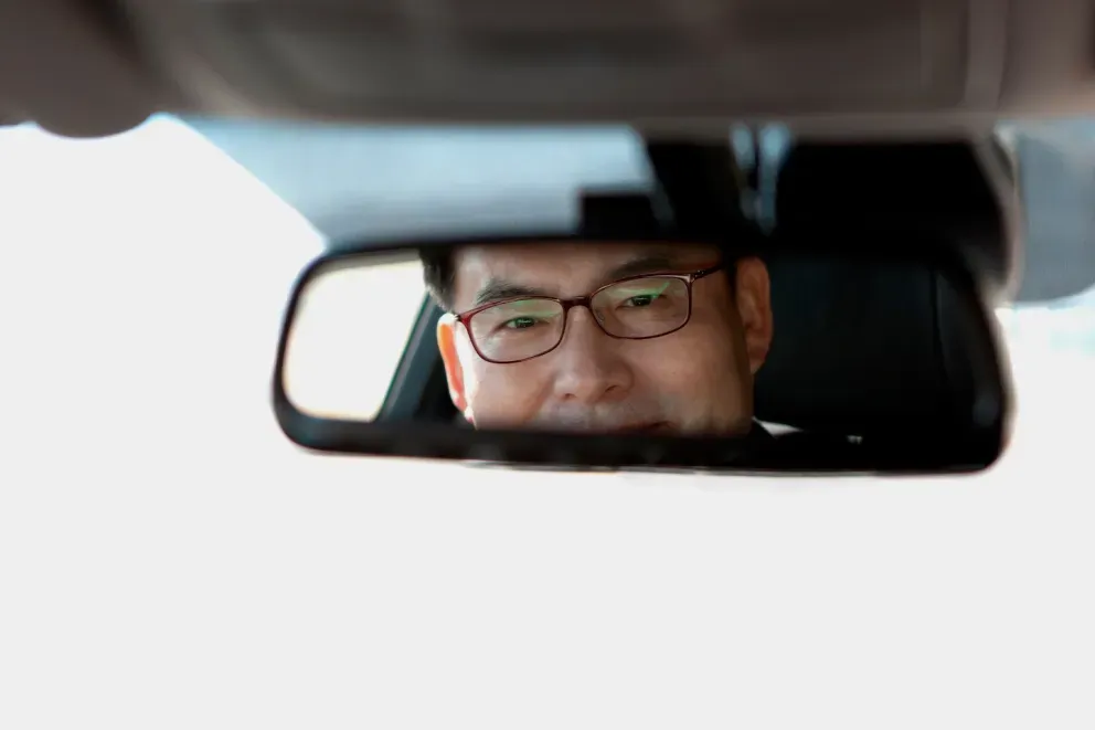 Man looking in rearview mirror