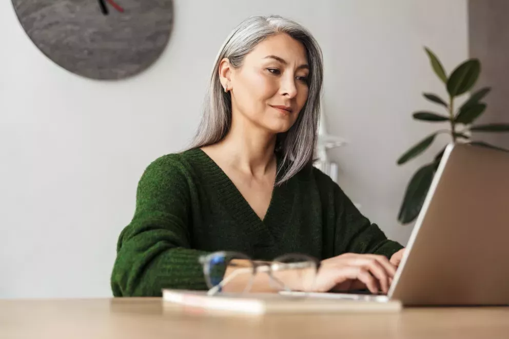 woman smiling and typing on laptop woman smiling and typing on laptop
