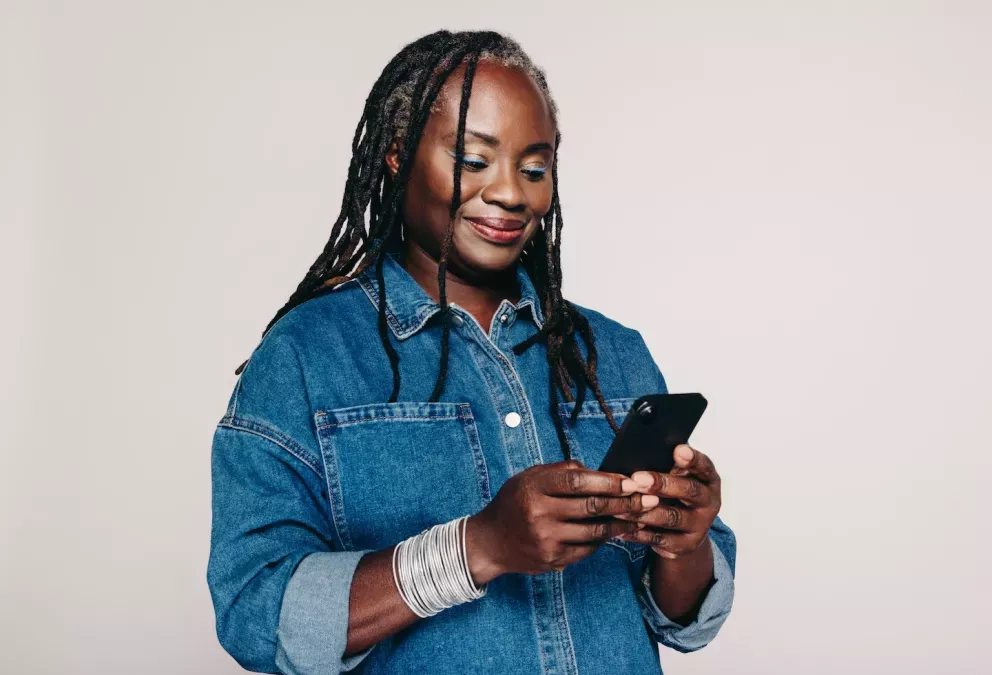 woman smiling while looking down at phone woman smiling while looking down at phone