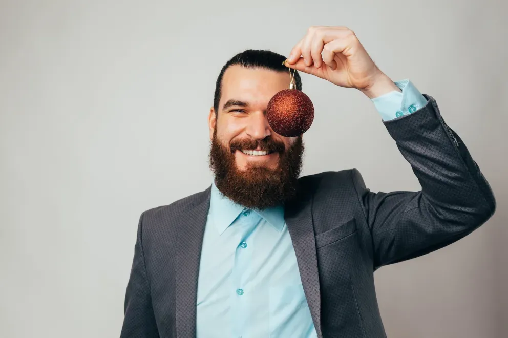 smiling man holding ornament up 