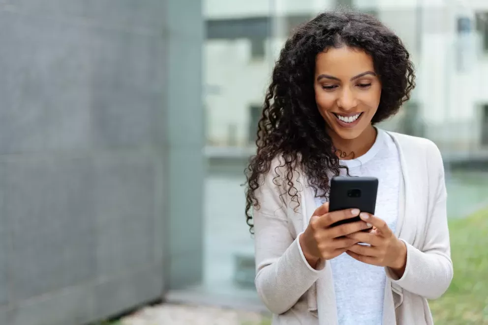 smiling woman looking at phone smiling woman looking at phone