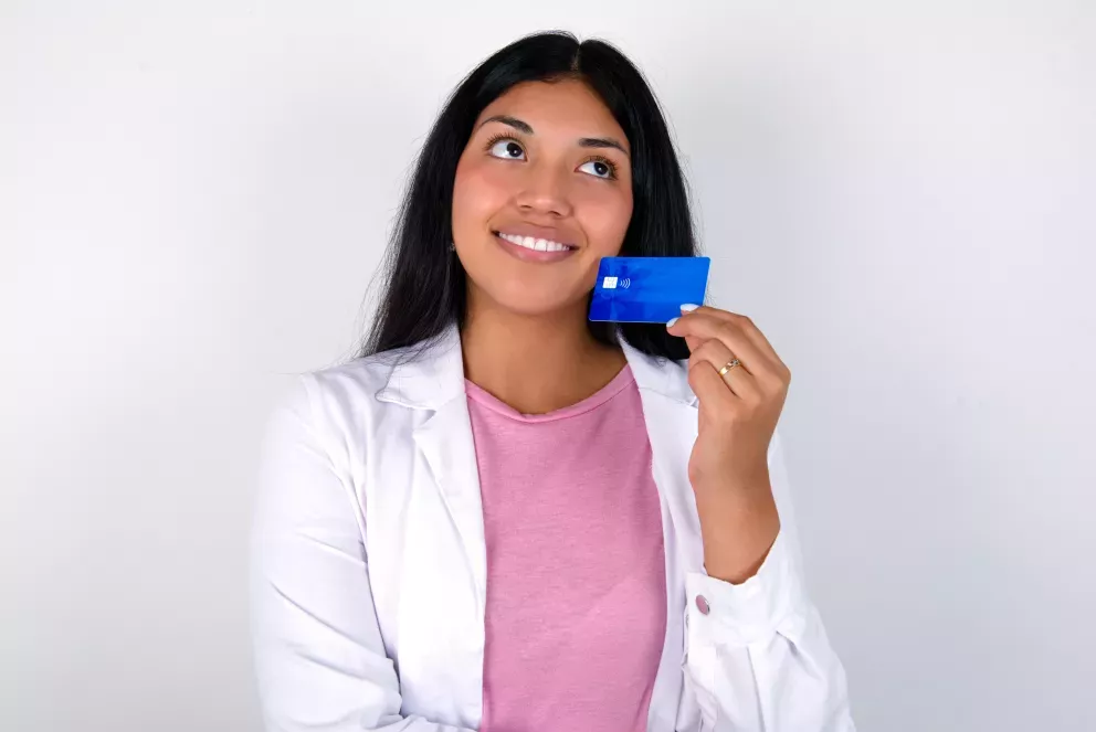 Woman with dark hair holding up her bank card and smiling Woman with dark hair holding up her bank card and smiling