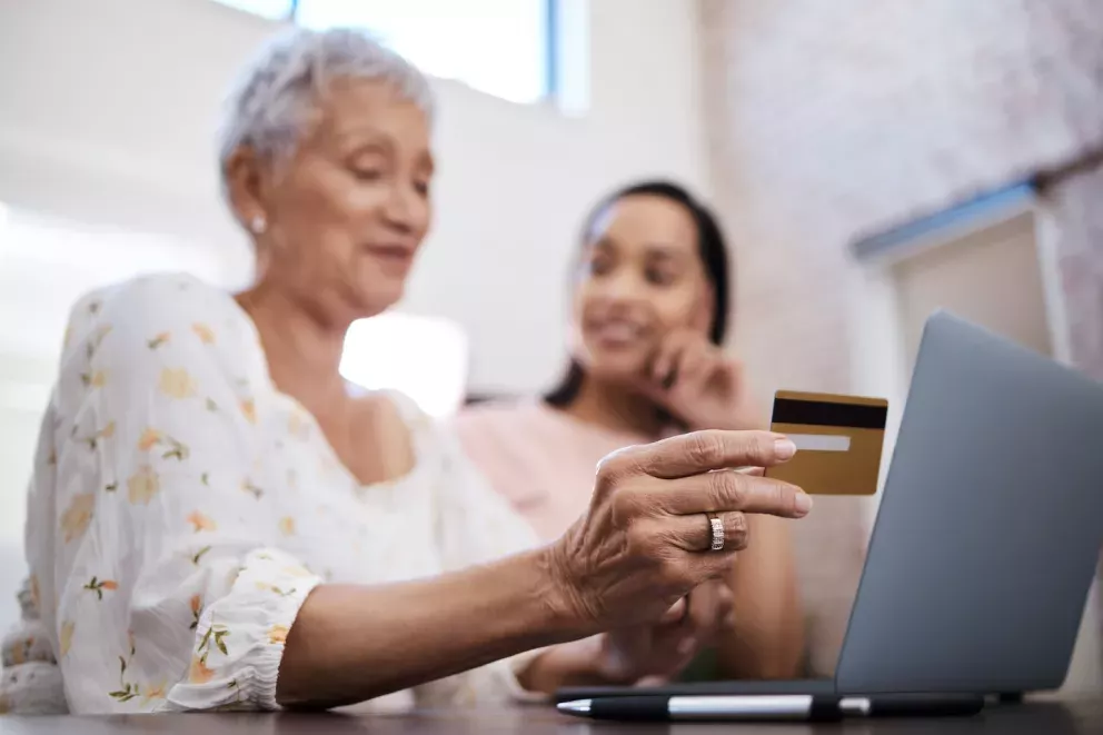 woman using a credit card at a computer