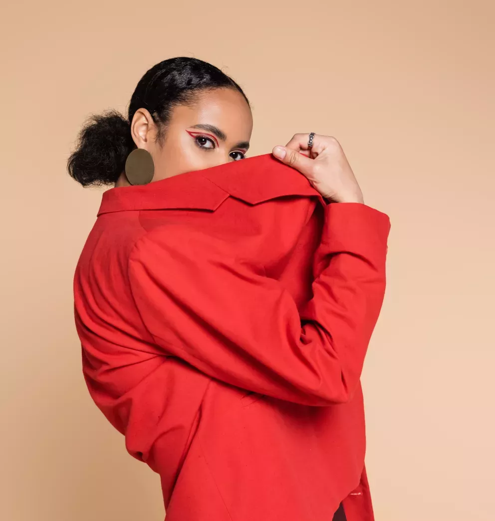 Woman in red jacket hiding her face with red eyeliner Woman in red jacket hiding her face with red eyeliner