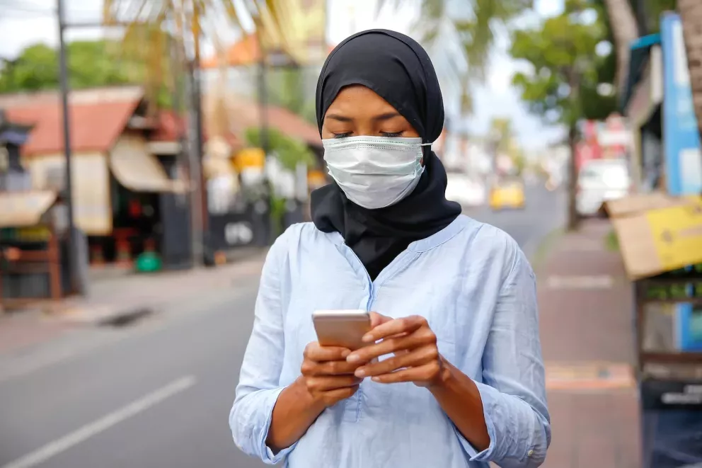 Woman with mask on phone Woman with mask on phone
