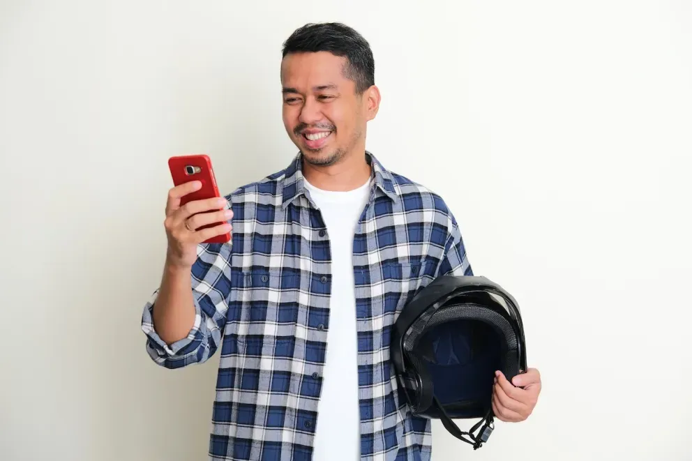 Smiling man with phone and helmet