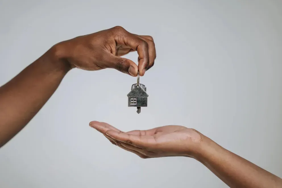 Two hands passing house keys Two hands passing house keys