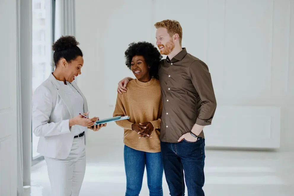 A couple speaking to a person with a clipboard