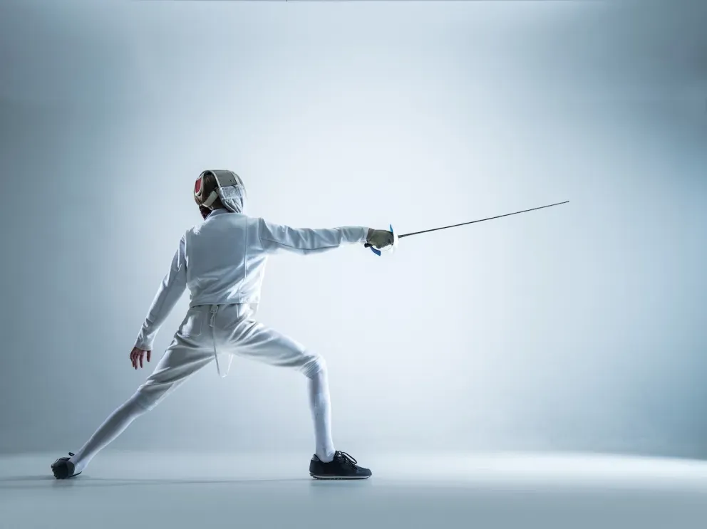 Person fencing gear with fence sword drawn