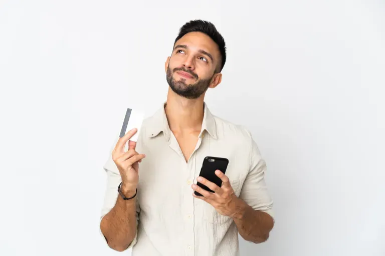 Inquisitive man with phone and card Inquisitive man with phone and card