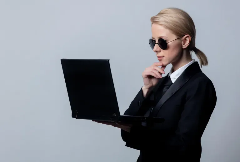 Person holding laptop with sunglasses on
