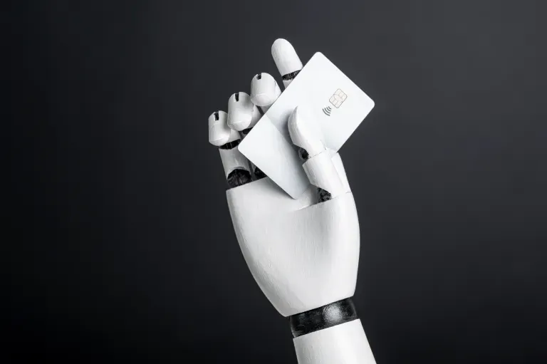 White robotic hand making a fist against a dark gray background.