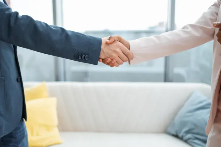 Two people shaking hands in a office setting Two people shaking hands in a office setting