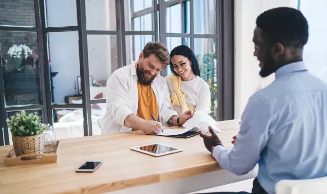 happy couple signing paperwork for new purchase
