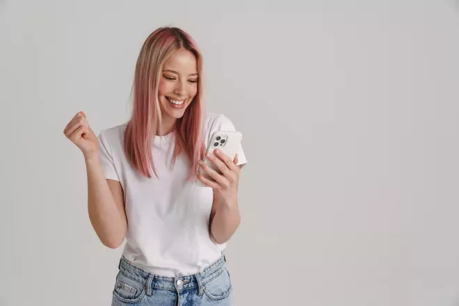 excited woman holding cell phone