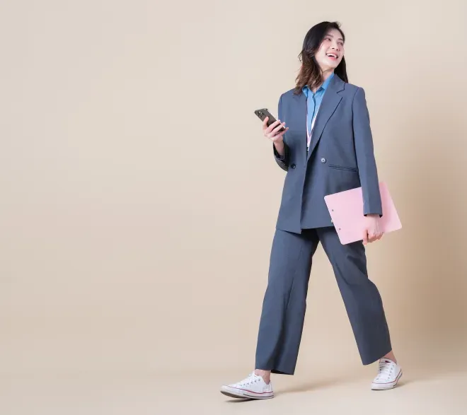 smiling person holding cellphone and clipboard