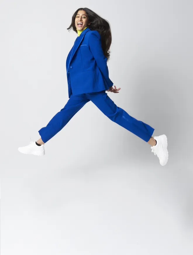 woman in business suit leaping