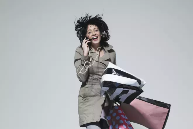 person talking on phone holding shopping bags