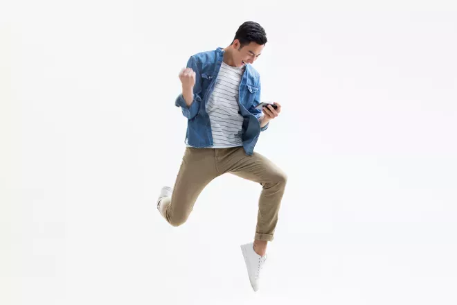 person jumping looking at phone