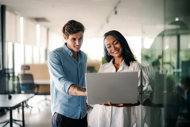 Business man and woman looking at laptop in office