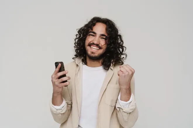 man smiling holding cell phone