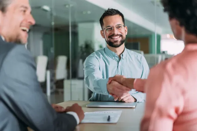 smiling business man shaking clients hand