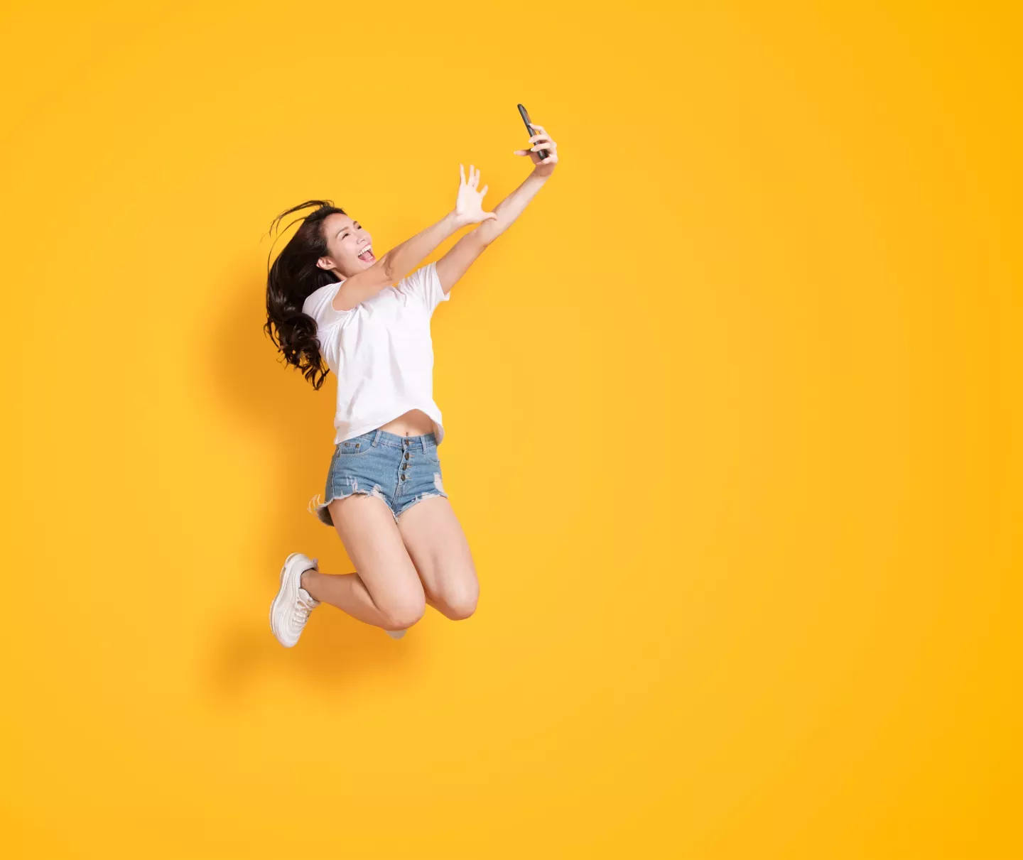 Woman jumping looking at a phone