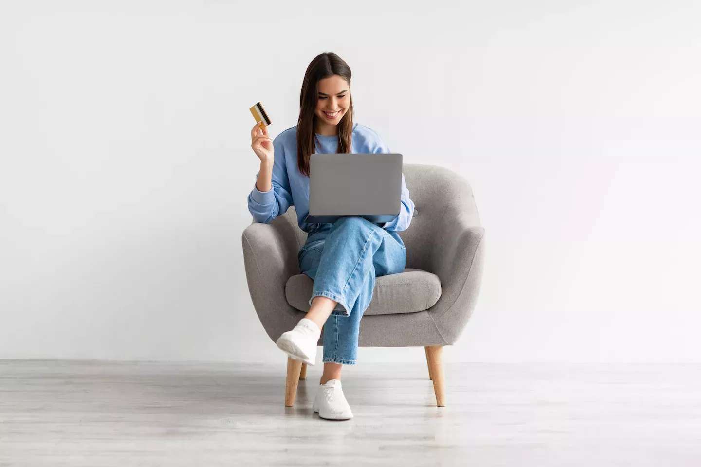Woman sitting in a chair holding a credit card