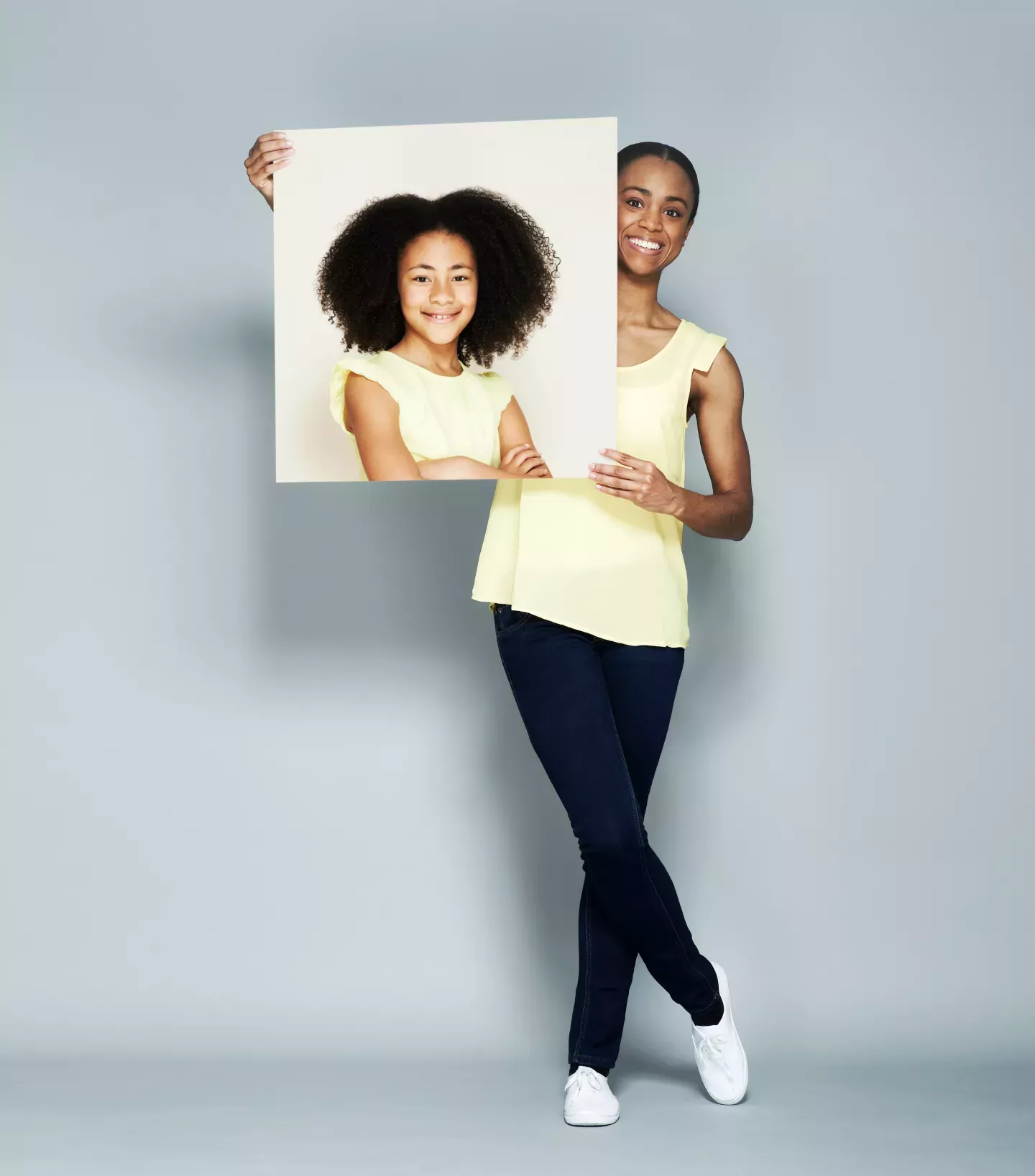 Woman holding a picture of herself as a child