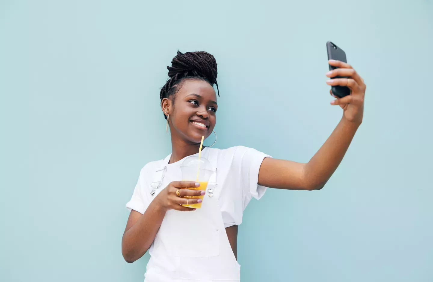 woman taking selfie on blue wall