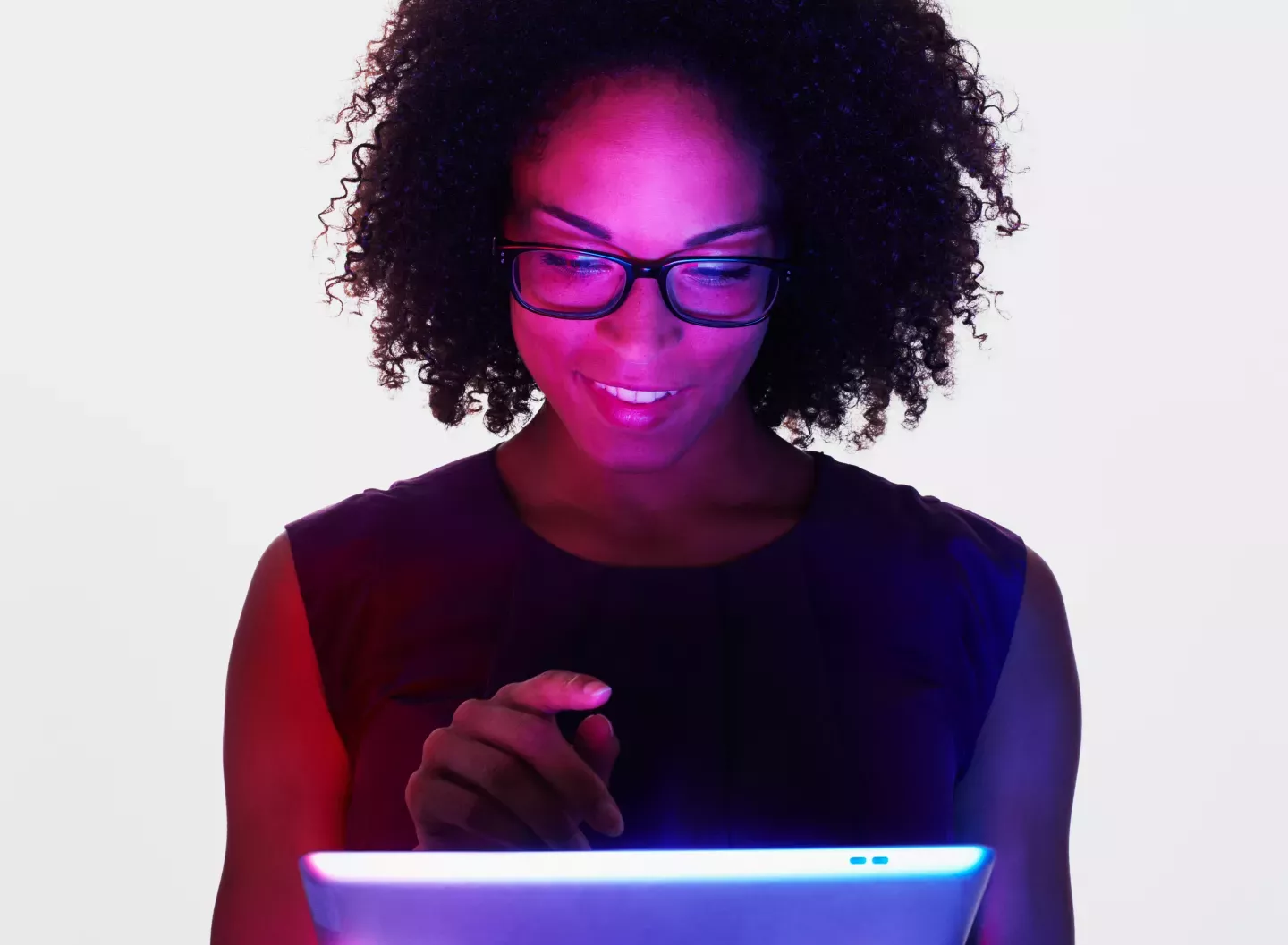 person sitting in the dark with the glow of laptop lighting up face