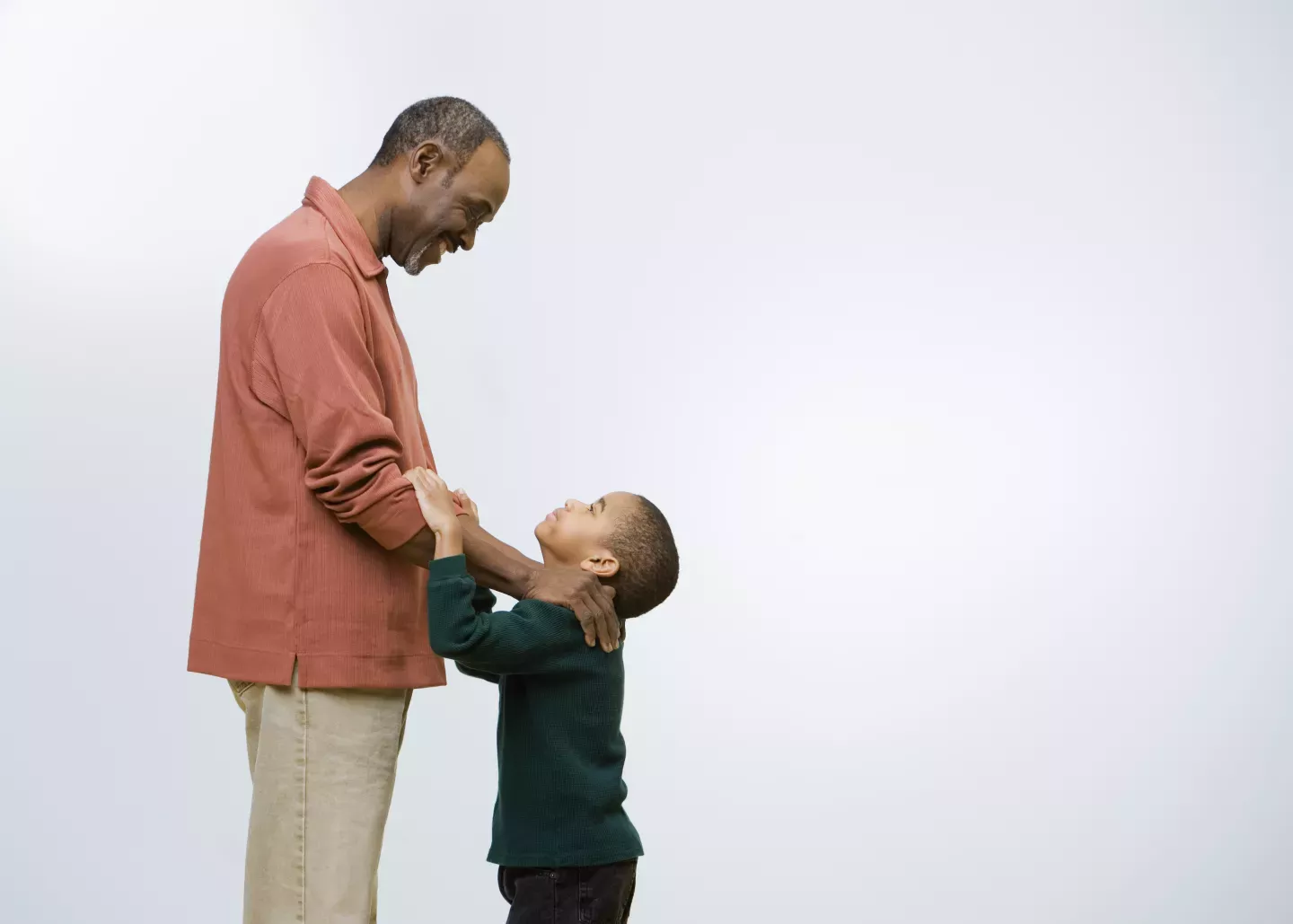 young son looking up at smiling father