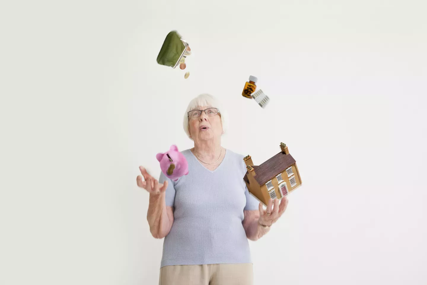 woman juggling piggy bank house purse and medications