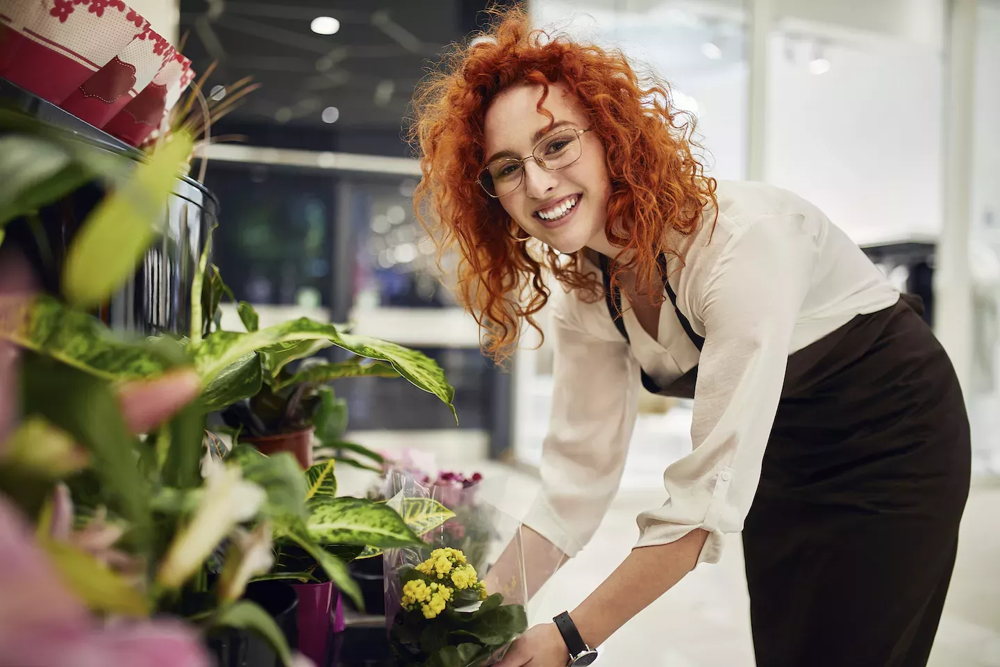 Florist smiling and arranging flowers