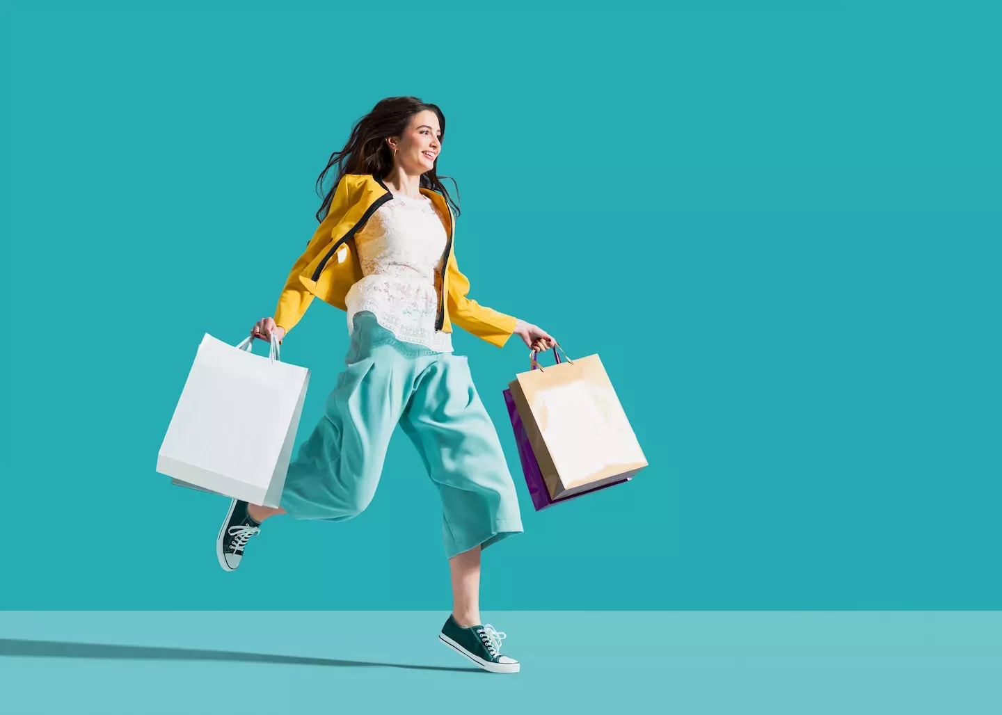 Woman jumping holding shopping bags