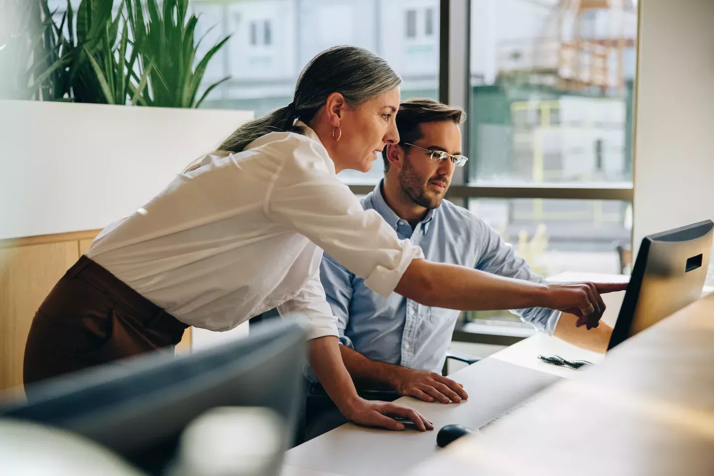 two people working at a desk two people working at a desk