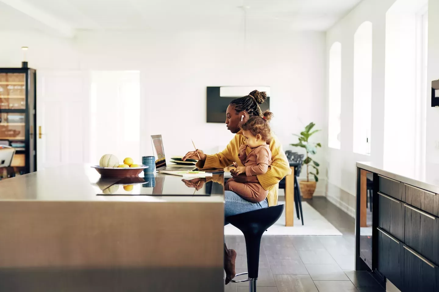 Woman working from home with child on her lap.
