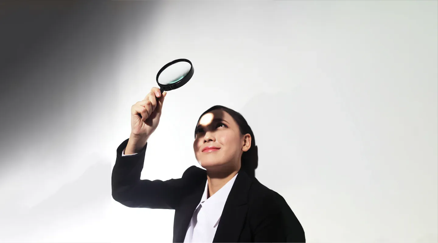 Woman looking through magnifying glass