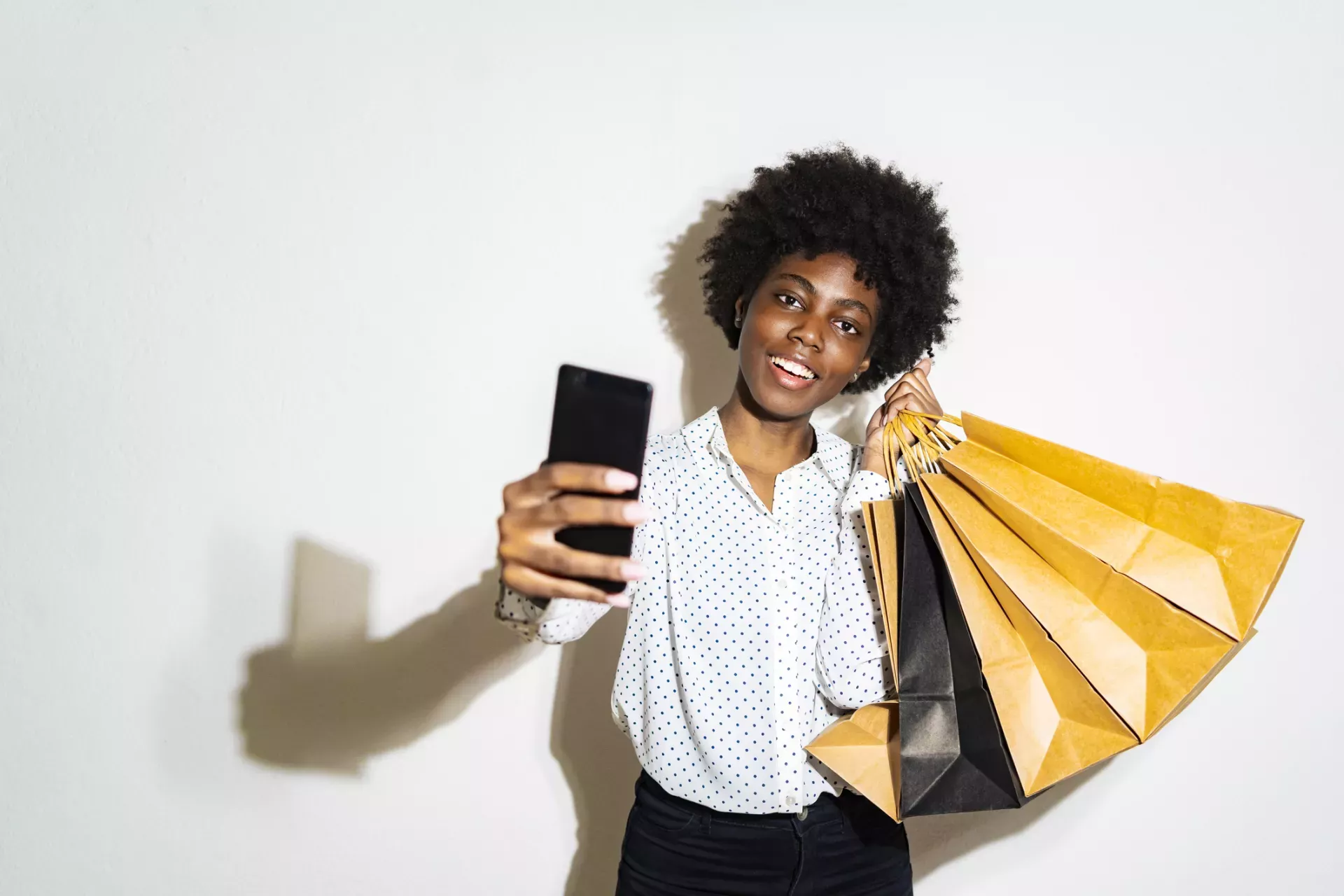 Woman holding shopping bags and taking selfie