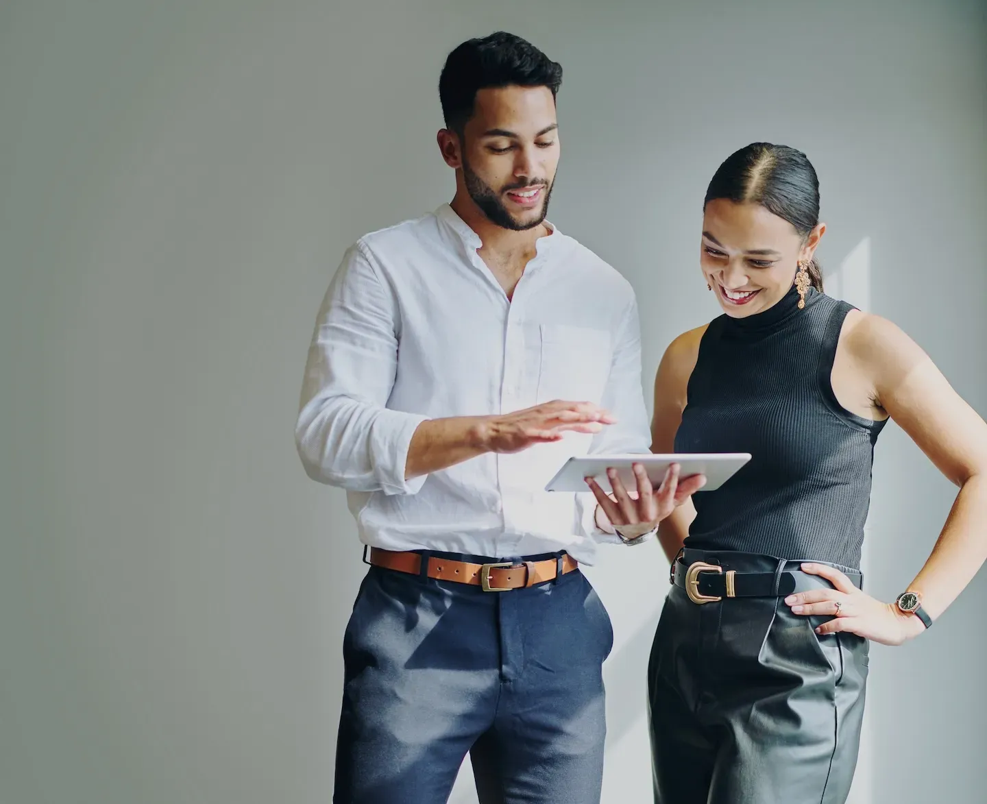 smiling business man and woman sharing ideas on an ipad smiling business man and woman sharing ideas on an ipad