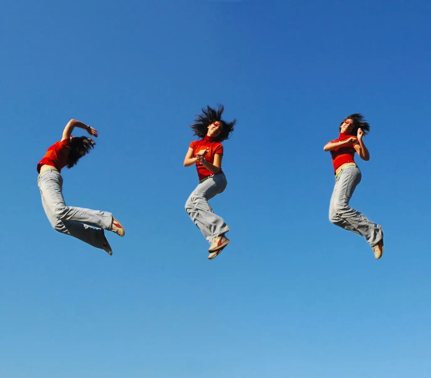 Three sequential shots of a woman in a red top jumping energetically against a clear blue sky.
